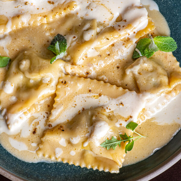 raviolli recheado com ragu de carne assado lentamente e finalizado com creme de queijos